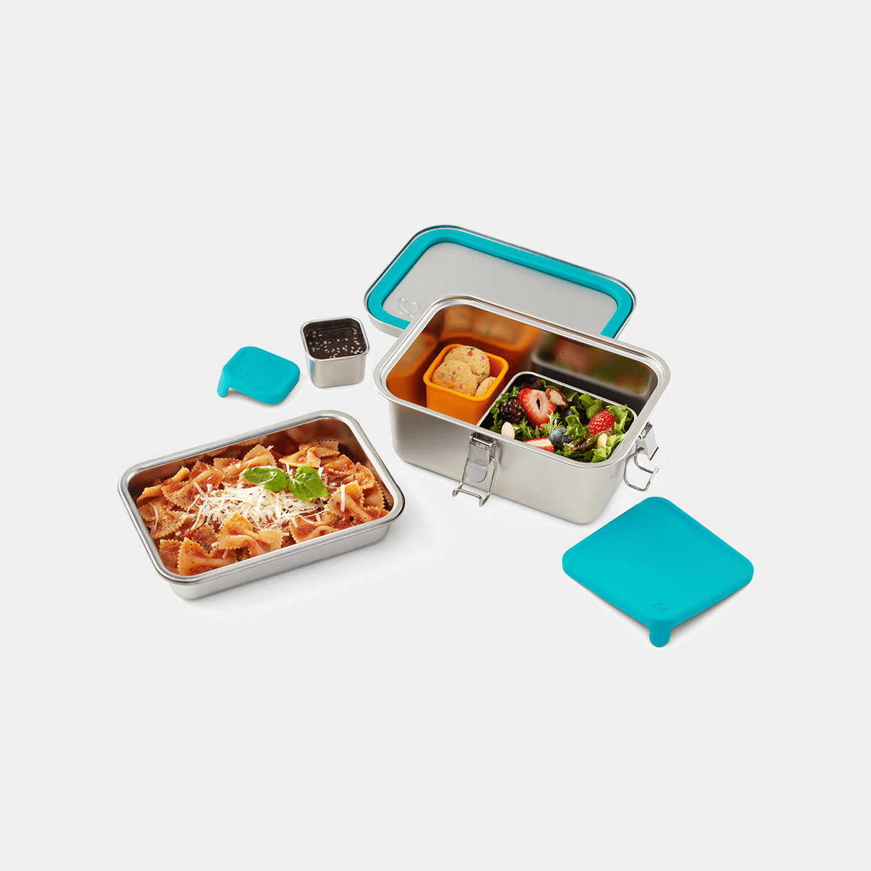 Top down view of Explorer lunchbox with different components in use, microwaveable tray with pasta, lid with seal facing upwards, and larger bottom tray featuring salad and snack pods in use.