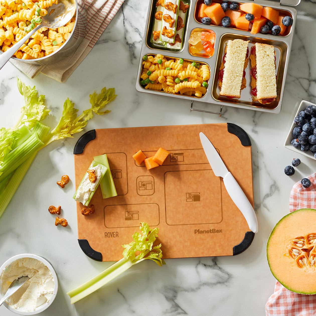 PlanetBox Prep to pack cutting board in use with lunch prepared nearby.