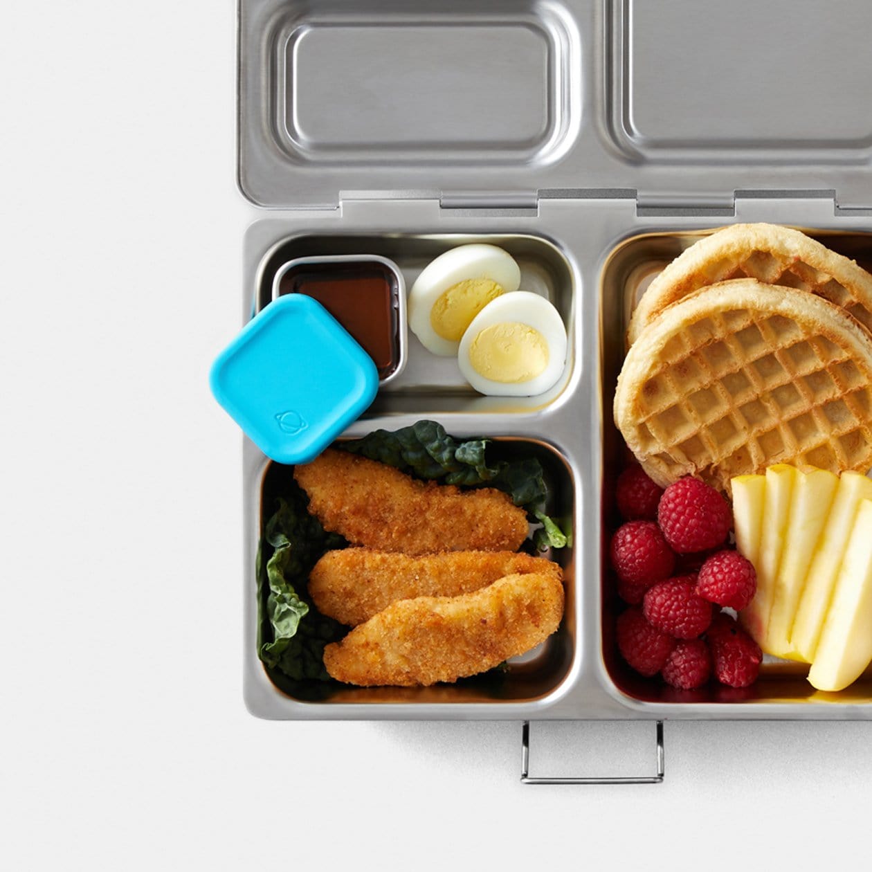 Top down view of Launch lunchbox filled with food, and Little Square Dipper filled with Syrup inside.